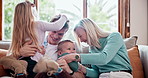 Happy, playing and children with parents on sofa in the living room of modern family home. Smile, bonding and young kids being playful with mother and father in the lounge together at house together.