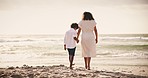 Beach, back and mother holding hands with boy child while walking nature with love, security and freedom. Ocean, travel and family rear view at sea with support, bond and summer, vacation or holiday