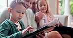 Happy, tablet and children with grandparents on a sofa in the living room at modern home. Smile, playing and kids with grandmother and grandfather on digital technology in the lounge at family house.