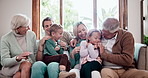 Happy, tickling and children with parents and grandparents on a sofa in the living room at home. Smile, playing and kids with mother, father and senior people in retirement in the lounge at house.