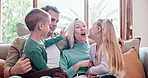 Happy, talking and children with parents on a sofa in the living room of modern family home. Smile, bonding and young kids relaxing and speaking with mother and father in the lounge together at house