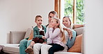 Happy, conversation and children with parents on a sofa in the living room of modern family home. Smile, bonding and young kids relaxing and talking with mother and father in lounge together at house