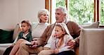 Watching tv or streaming with grandparents and children on a sofa in the living room of a home during a visit. Relax, subscription or entertainment with senior people looking after their grandkids