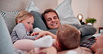 Happy family, play and laughing on bed with tickling, love and bonding together for relax weekend in house. Young couple, kids and care in bite games, morning and health wellness on vacation in home