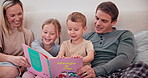 Parents children and reading books in bedroom for learning, language development and care for knowledge. Happy mom, dad and excited kids relaxing for bedtime, storytelling and together in family home