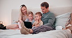 Parents, children and tablet in bedroom for games, reading ebook and streaming multimedia at home. Mom, dad and happy family of kids relax with digital technology, watching cartoons and movies on bed