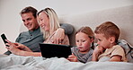 Parents, children and tablet in bedroom, watching and playing in bed, technology and smile. Happy, enjoying and online for childhood, digital and internet in family home, games and bonding together