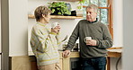 Senior couple, coffee and talking in kitchen with love, care and commitment to marriage at home. Old man, elderly woman and drinking cup of tea with conversation, chat and communication in retirement