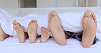 Family, bed and feet together in sheet, kids and play in home with games, hospitality or comfort with bonding. People, children and bedroom with toes, blanket and sole to relax, holiday or vacation