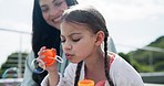 Outdoor, mom and child blowing bubbles, smile or family bonding together at home. Mother, kid play with soap toys in summer and happy young girl having fun, freedom or love and care of mama at house