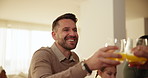 Happy, cheers and young man at dinner in the dining room of modern home for family time. Smile, love and male person from Canada with glass of juice for toast at supper or lunch in house or apartment