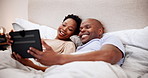 Home, bed and black couple with a tablet, love and morning with connection, smile and laughing. Bedroom, man and woman with technology, bonding together and happiness with a weekend break and humor