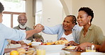 Happy, black family and children at table for lunch, supper and eating meal at home together. Grandparents, parents and kids with food for bonding, relax and talking in dining room for nutrition