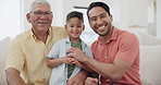 Proud dad, son and grandfather on a sofa in the living room of a home together during a visit for bonding. Portrait, smile or love with a happy senior man, son and grandchild in their apartment