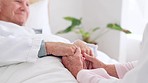 Love, comfort and senior couple holding hands in bedroom at nursing home for support in marriage. Compassion, sweet and closeup of elderly man and woman in retirement with affection at modern house.