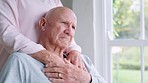 Comfort, support and couple holding hands in wheelchair by window for thinking in living room at home. Love, compassion and closeup of elderly man with disability and woman in retirement at house.