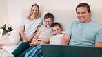 Happy, laptop and parents with children in the bed watching a movie, show or film at home. Smile, happiness and young mother and father relaxing with boy kids in bedroom of modern family home.