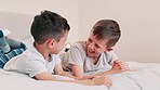 Children, laughing and conversation on bed, fun and silly jokes in discussion. Happy boys, kids and laughing for communication, bonding and love for siblings, kids and talking in bedroom at home