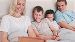 Tablet, smile and parents with children in bed watching a movie, film or show online on the internet. Happy, digital technology and young mom and dad with boy kids relaxing and scroll on social media