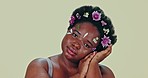 Face, flowers and beauty with a body positive black woman in studio on a gray background for natural wellness. Portrait, skincare and a confident young plus size model feeling her aesthetic skin