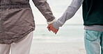 Back, beach and a parent holding hands with a kid while standing outdoor on sand by the coast. Family, children and people on holiday or vacation together during summer for travel and bonding closeup