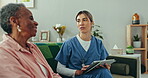 Elderly, woman and caregiver with tablet for consulting, communication and discussion for healthcare on sofa. Senior, person and nurse with touchscreen for conversation for health, report or analysis