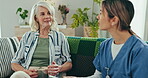 Elderly, woman and nurse with tablet for consulting, communication and discussion for healthcare on sofa. Senior, person and caregiver with touchscreen for conversation for health, report or coffee