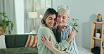 Love, hug and woman with senior mother in a living room with care, support and security. Happy, embrace and female person with elderly mom in a house for weekend, visit or reunion in family home