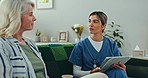 Therapy, old woman on sofa and nurse with tablet, support and advice for healthcare in home. Homecare, elderly patient and caregiver in living room for consultation, help and kindness in conversation