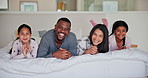 Parents, girl children and bed with face, smile and together with interracial love, care and bonding in house. Father, mother and daughter kids in bedroom, relax and happy in portrait at family home