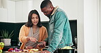 Man, woman and cellphone with online recipe in kitchen, communication and bonding with cooking in home. Interracial couple, happy and love with phone with nutrition, tabletop and discussion in house