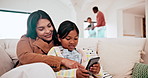 Happy, phone and child with mother on a sofa networking on social media in the living room of modern home. Bonding, technology and girl kid scroll on cellphone with Asian mom in the lounge of house.