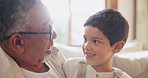 Smile, love and grandfather hug child on sofa with support, trust and security at home. Happy, face and senior man embrace kid in living room for bond, conversation and retirement with babysitting