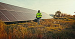 Technician walking at solar panel farm for inspection, clean energy and outdoor electricity maintenance. Sustainability, photovoltaic power and man with tools for renewable system at electrical plant