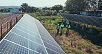 People walking at solar panel plant for inspection, clean energy and outdoor electricity grid maintenance. Sustainability, photovoltaic power and men in talk with renewable system at electrical farm.