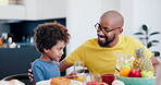 Man, child or communication with orange juice by table, lunch outing or nutrition with happiness in home. Father, son and smile with sip drink, vitamin c and fruit health wellness at dinner in house