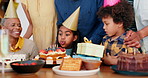 Birthday party, family and girl blow candles for celebration, success and grandmother singing, excited and support. Happy interracial people, kids or children with cream cake and dessert at home