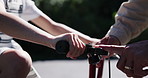 Closeup, hands and people with bicycle in street, neighborhood or road with advice for brake, speed and bell. Family, father and daughter for bonding with fun, activity or teaching to ride in summer