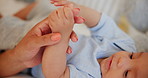 Mother, holding hands and baby for playing, bed and development with care, growth and wellness. Mom, newborn and infant in closeup, love and bonding in nursery, bedroom and together in family home