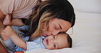 Happy, kiss and baby with mom in bed playing, bonding and  relax together in morning with fun. Infant, smile and mother with love, care and support for child in bedroom, home or house with funny game