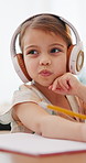 Writing, homework and child with headphones for education, online learning and studying in home. School, virtual classroom and young girl with technology for knowledge, internet lesson and project