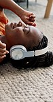 Music, headphones and happy black woman on floor in home living room, listening to audio or sound to relax. Smile, radio and African person on carpet streaming, hearing song and enjoy freedom on tech