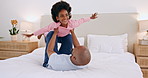 Black family, father and a daughter flying in the bedroom in their home together for playing or bonding. Smile, fantasy plane and a man parent having fun with his girl child on an apartment bedroom