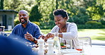Family eating lunch, garden and happy at thanksgiving with bonding, care or love for celebration. Black people, patio and brunch at table for party, event or conversation for meat,  chicken or diet