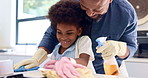 Cleaning, dad and child in house learning with gloves, cloth and wipe a dirty table for hygiene. Kid, helping and spray for bacteria disinfection on countertop surface in home with support and care