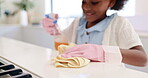 Cleaning, kitchen counter and child in house learning with gloves, cloth and wipe a dirty table for hygiene. Kid, helping and disinfecting spray with bacteria on countertop surface in home with chore