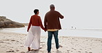 Travel, holding hands and an old couple walking on a beach together at sunset for romance in summer. Back, nature or freedom with an elderly man and woman pointing at the ocean or sea for bonding