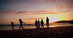 Sunset, running and silhouette of family at the beach on a summer vacation, holiday or weekend trip. Travel, evening and shadow of people having fun together by the ocean or sea on tropical getaway.