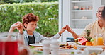 Family, holding hands and praying at lunch, together and table with kid, grandparents and thanksgiving celebration. People, religion and faith with connection, peace and gratitude for food at house