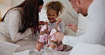 Bedroom, tickle and child with parents playing for love, bonding and loving relationship. Family, home and happy mother, father and young girl with pillows for playful, games and relaxing on bed